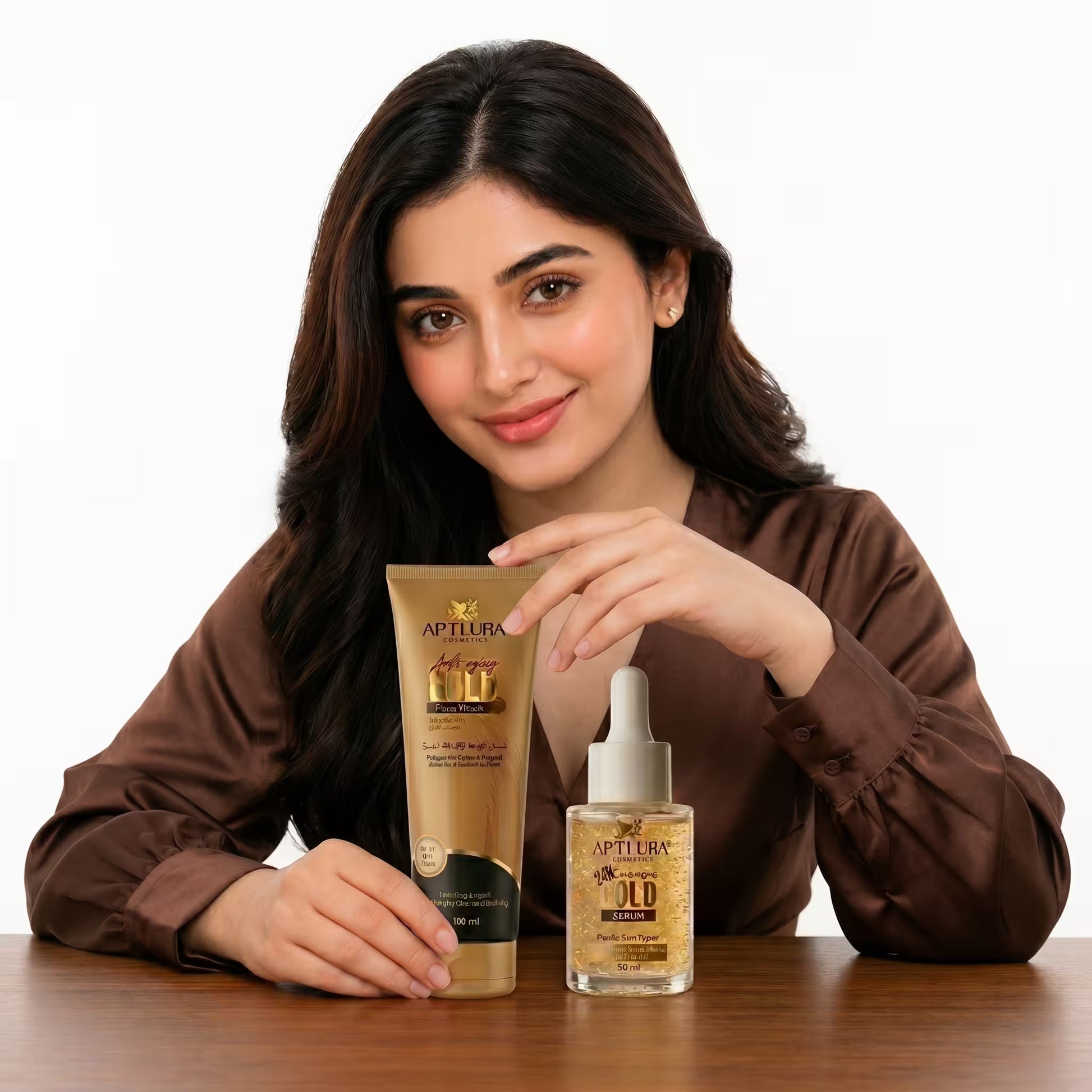 Woman holding a tube of Aptlura skincare product on a wooden table with a white background