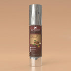 Argan oil hair serum bottle with silver cap on a beige background