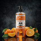 Hand wash bottle with pump dispenser surrounded by oranges on a dark background