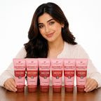 Woman holding six pink skincare products from Aptlura on a white background