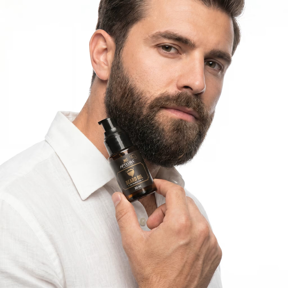 Man holding a bottle of beard oil with a white background