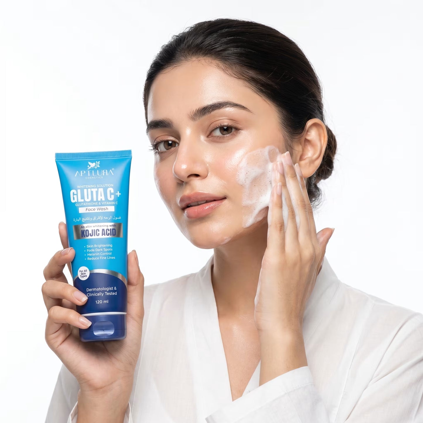 Woman applying skincare product to her face with a blue Gluta C+ tube in hand on a white background