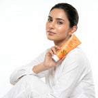 Woman holding an orange tube of sunscreen with a white background