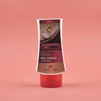 Red onion conditioner bottle with Aptlura branding on a pink background