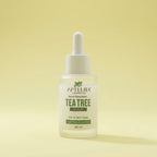 Tea tree serum bottle with dropper on a yellow background