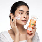 Woman applying facial cream with a tube of Aptlura Vitamin C product on a white background