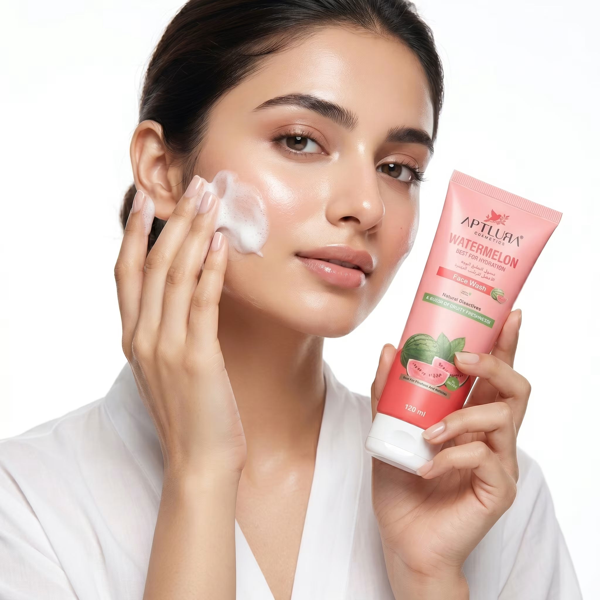 Woman applying cream to her face with a pink skincare product labeled 'Aptlura' in the background.