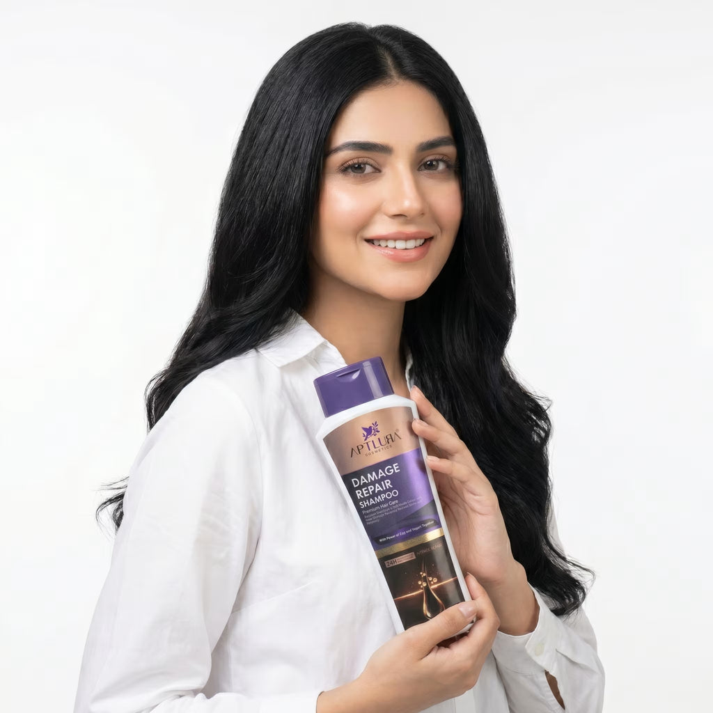 Woman holding a bottle of shampoo with a white background