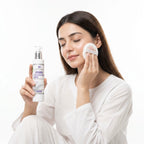 Woman applying facial cleanser with a bottle of Aptlura Cleansing Milk on a white background