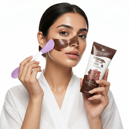 Woman applying coffee peel-off mask with brush and product packaging on a white background