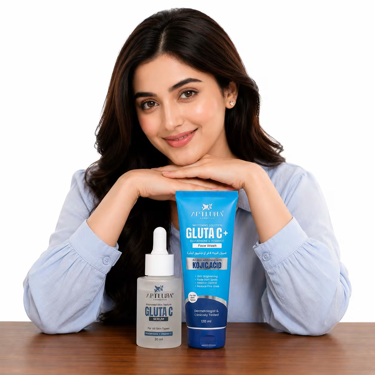 Woman with skincare products on a table, including a bottle and a tube of Aptlura Gluta C+.