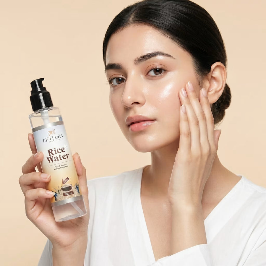 Woman holding a bottle of Aptlura Rice Water with a beige background