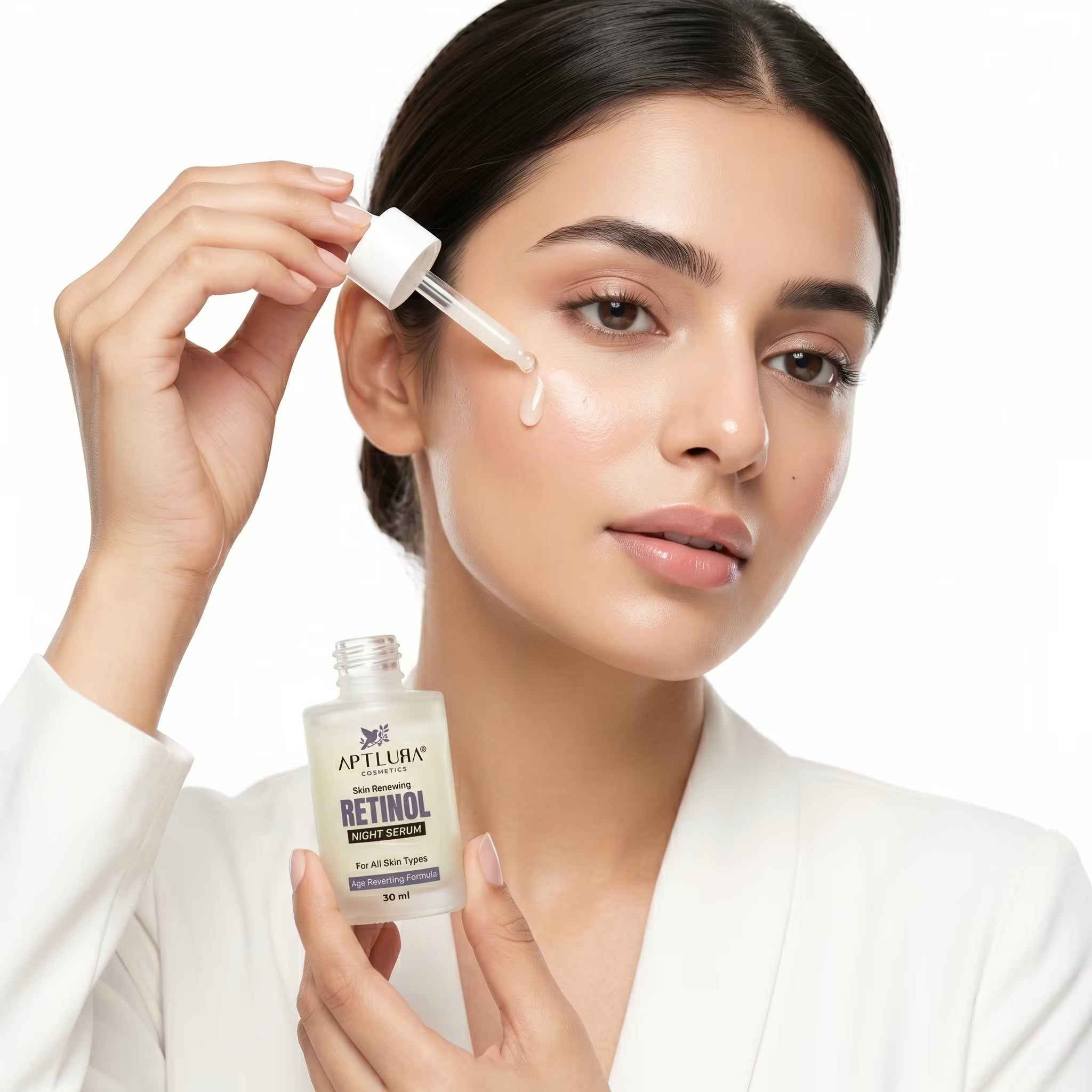 Woman applying a skincare product with a dropper to her face, holding a bottle labeled 'Retinol'.